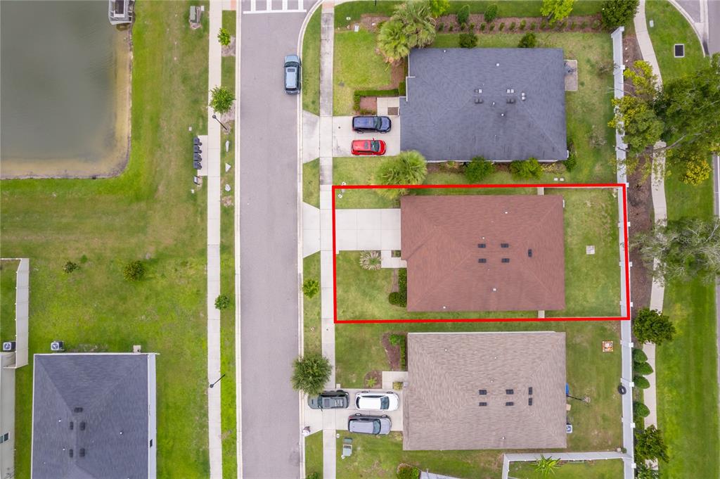 An aerial view shows a residential house with a brown roof and a fenced yard — 2405 BULRUSH DRIVE, ST CLOUD, FL