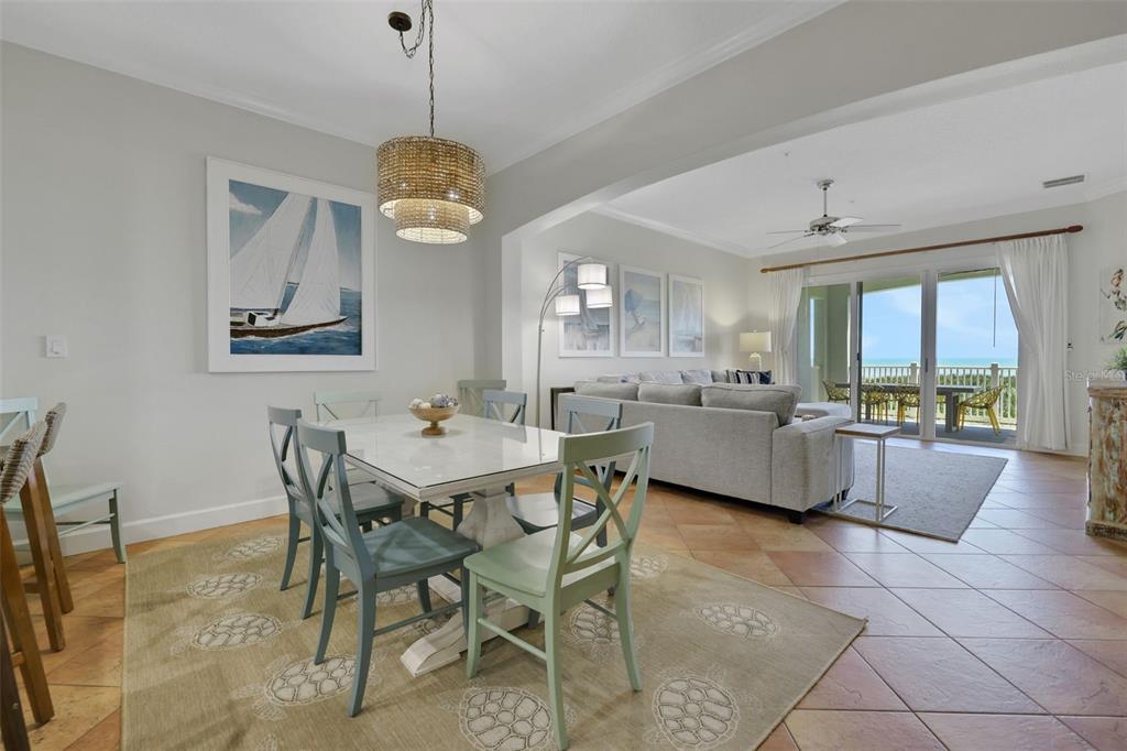A dining area with a light-colored table and chairs sits adjacent to a living room — 900 CINNAMON BEACH WAY UNIT 822, PALM COAST, FL