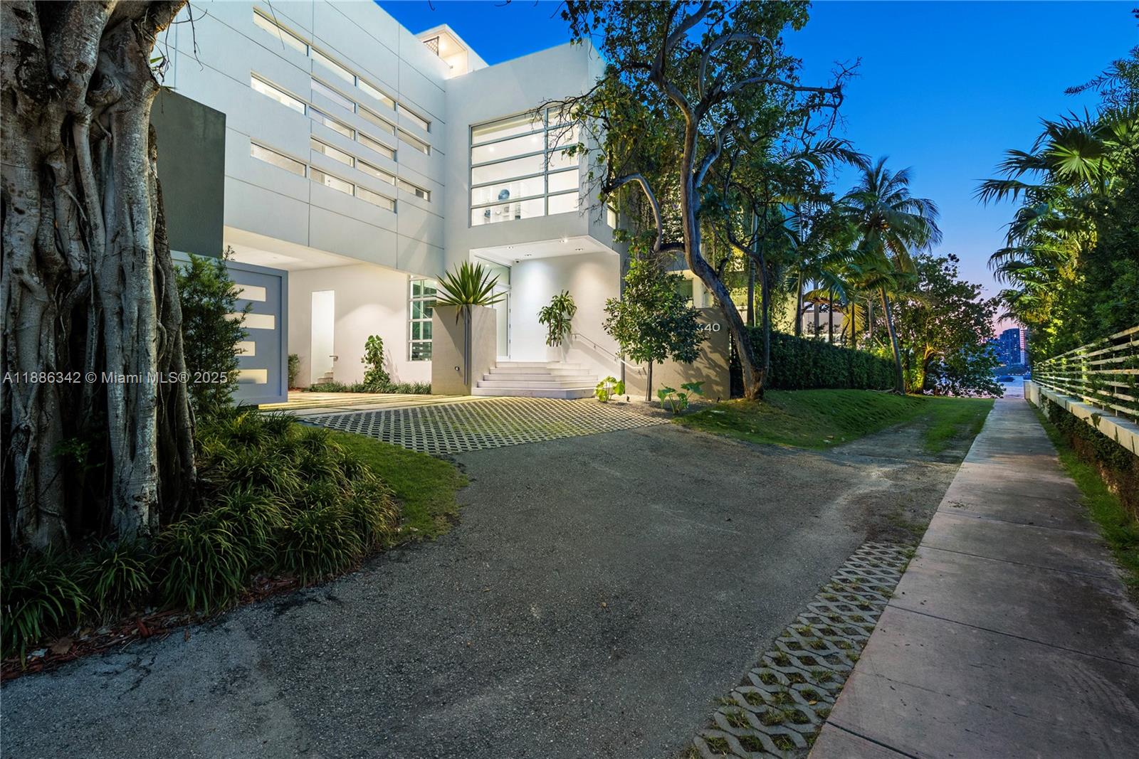 A modern white multi-story house features a paved driveway and a large glass window facade — 440 S Hibiscus Dr, Miami Beach FL 33139, MIAMI BEACH, FL