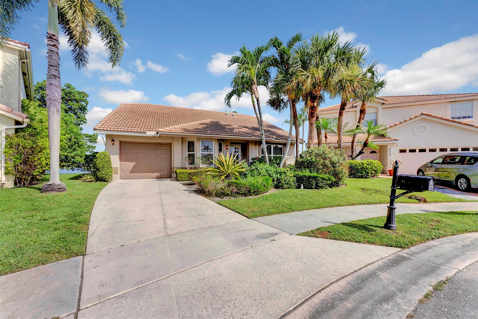 A single-story house with a tile roof, concrete driveway, and palm trees in the front yard — 7312 Heathley Drive, Lake Worth FL 33467, LAKE WORTH, FL