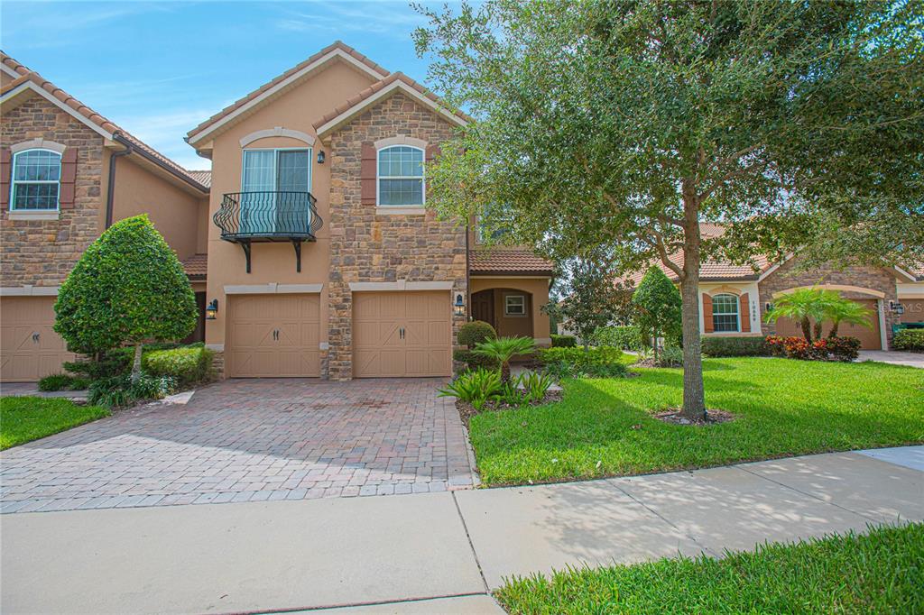 A living room features beige tile flooring, neutral walls, a sofa, and two swivel chairs — 10665 BELFRY CIRCLE, ORLANDO, FL