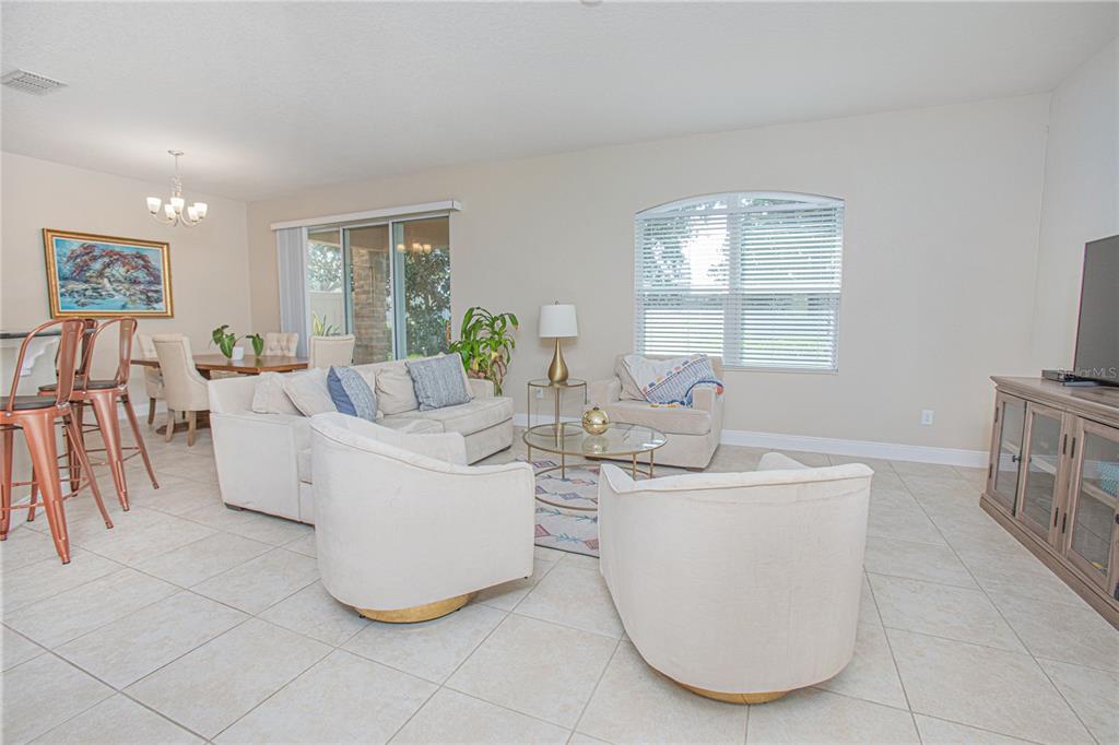 A bedroom features a white dresser, a bed with white bedding, and a window — 10665 BELFRY CIRCLE, ORLANDO, FL