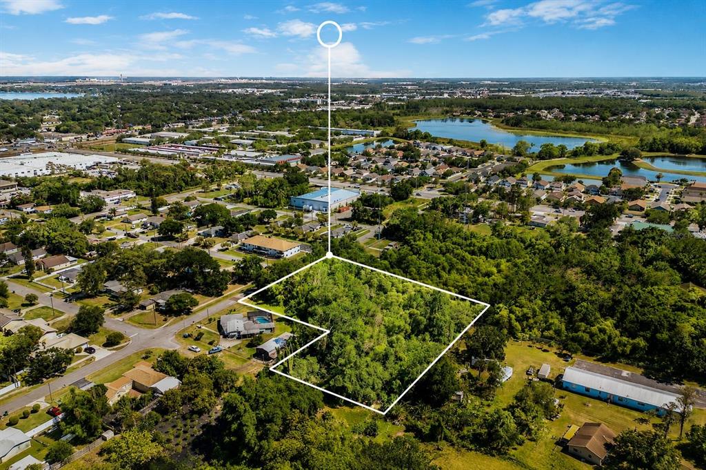 An aerial view shows a vacant, wooded lot outlined in white within a residential neighborhood — 110 PRINCE STREET, ORLANDO, FL