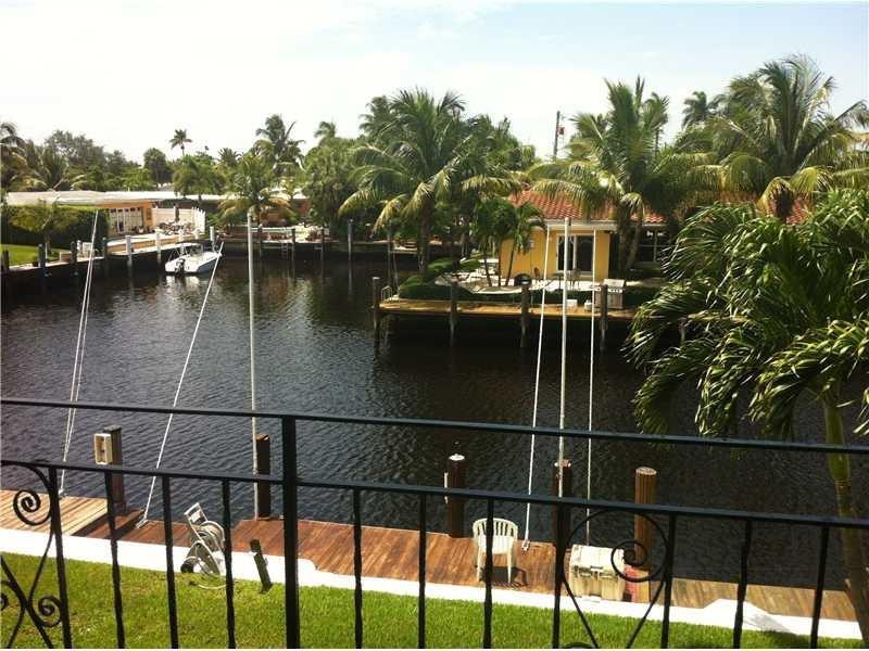 A view from a balcony overlooking a canal with a dock and a yellow house — 301 E Mcnab Road E # 106, Pompano Beach FL 33060, POMPANO BEACH, FL