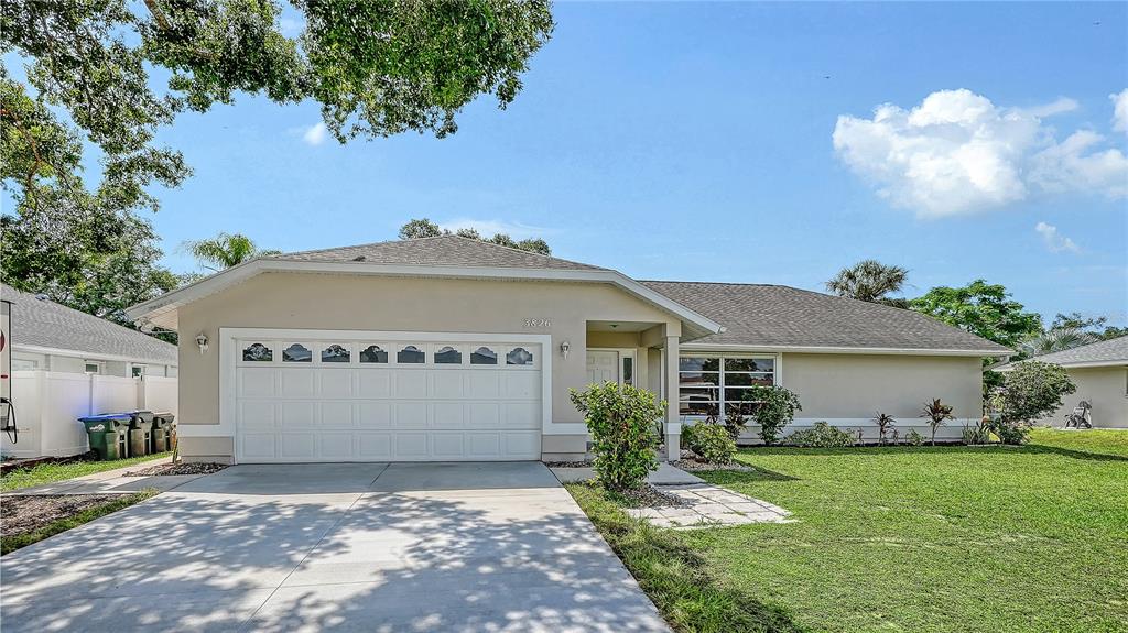 A single-story house with a beige exterior, a two-car garage, and a concrete driveway — 3826 BEEBER STREET, NORTH PORT, FL