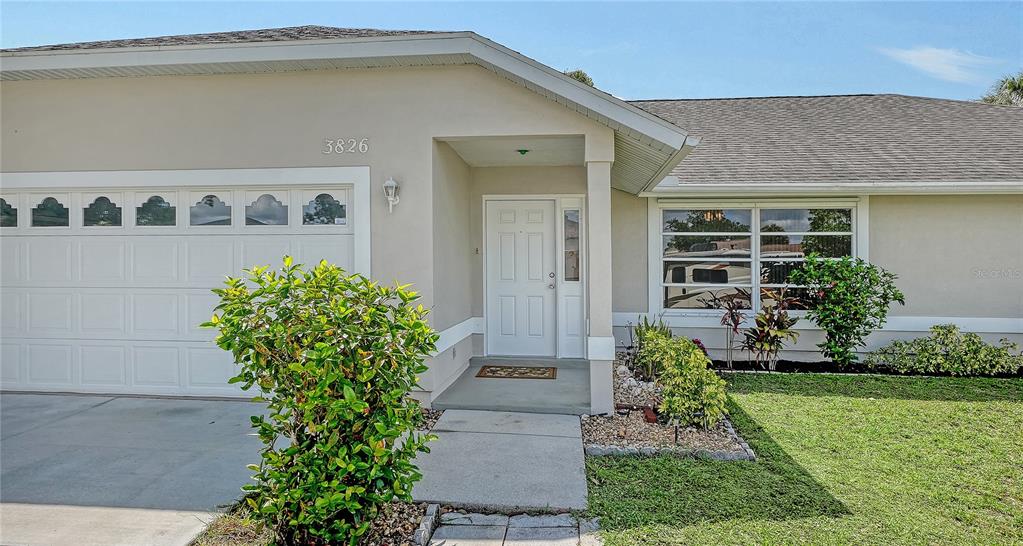 A single-story house exterior features a white garage, a front entrance, and a large window — 3826 BEEBER STREET, NORTH PORT, FL