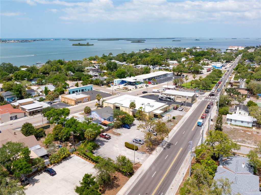 An aerial view shows a coastal town with commercial buildings, parking lots, and a road — 1610 N MYRTLE AVENUE, CLEARWATER, FL