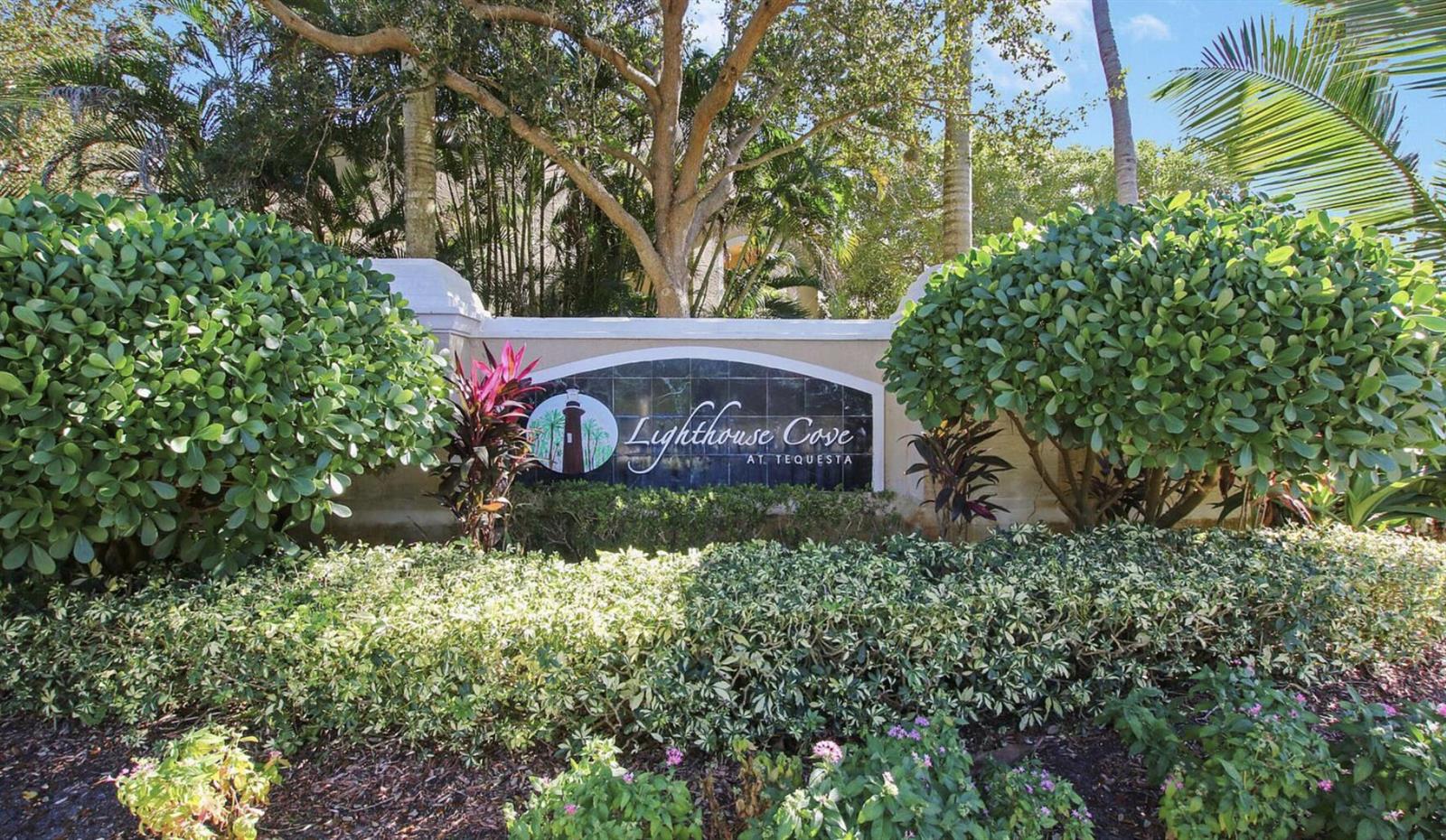 A stone monument sign for Lighthouse Cove at Tequesta sits amidst lush landscaping and trees — 266 Village Boulevard # 6102, Tequesta FL 33469, TEQUESTA, FL