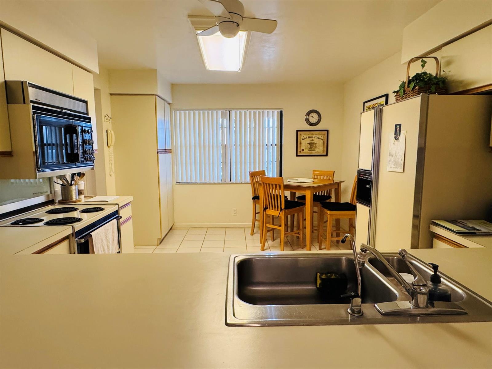 A kitchen with a breakfast nook, light-colored cabinets, a ceiling fan, and a stainless sink — 11190 Aspen Glen Drive, Boynton Beach FL 33437, BOYNTON BEACH, FL