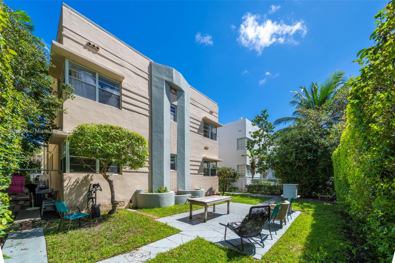 An exterior view of a tan Art Deco apartment building with a shared backyard patio — 1329 Pennsylvania Ave, Miami Beach FL 33139, MIAMI BEACH, FL