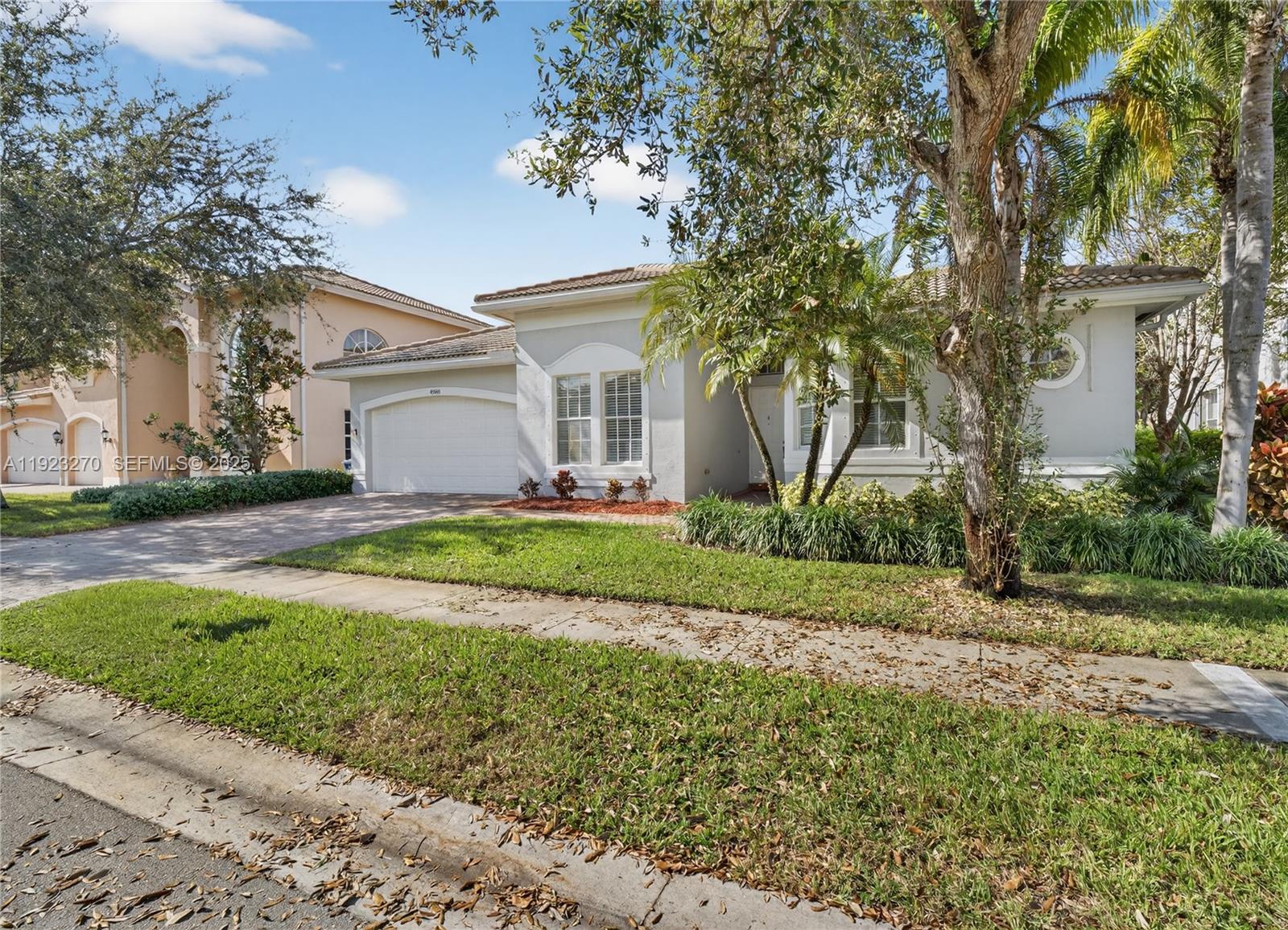 A single-story house with a white garage, light-colored stucco exterior, and a landscaped front yard — 4988 SW 183rd Ave, Miramar FL 33029, MIRAMAR, FL