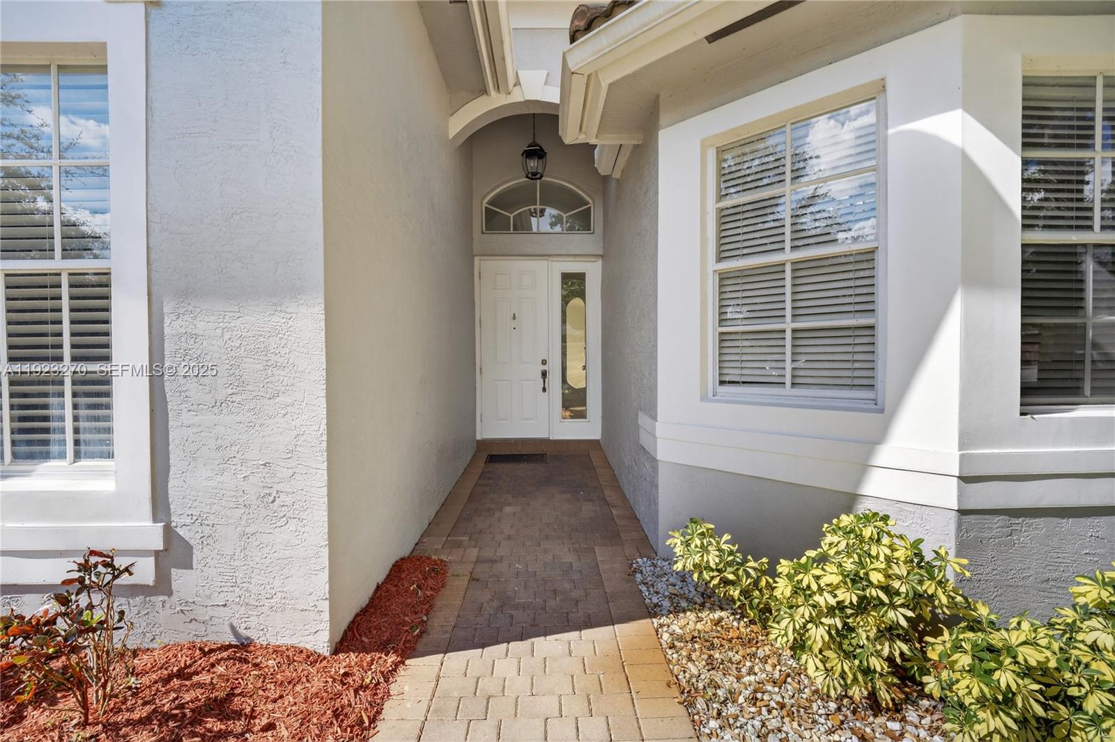 The exterior view shows a paved walkway leading to a white front door with sidelights — 4988 SW 183rd Ave, Miramar FL 33029, MIRAMAR, FL