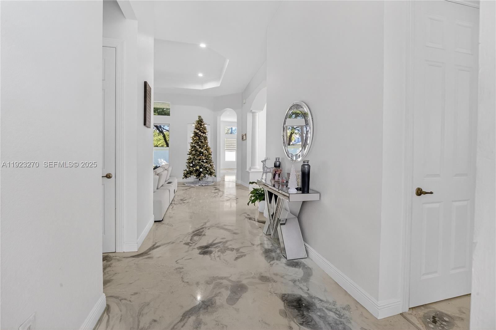 A bright hallway features a mirrored console table and unique marbled flooring — 4988 SW 183rd Ave, Miramar FL 33029, MIRAMAR, FL