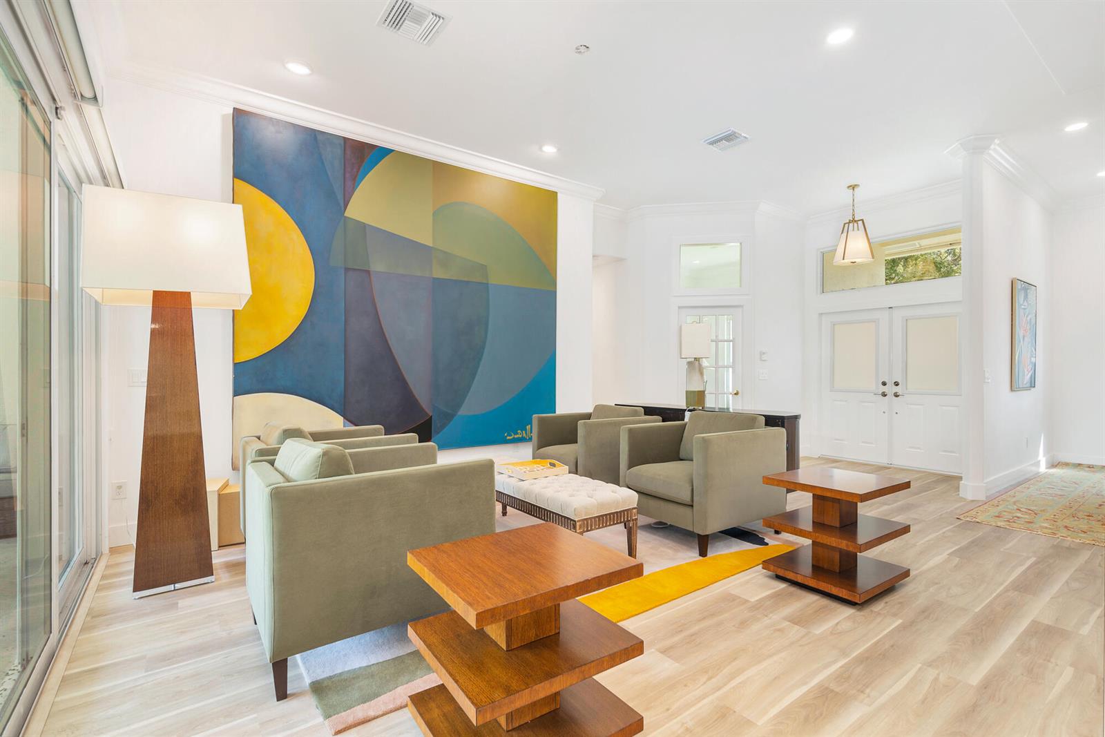 A living room features four sage green armchairs, two tiered wooden tables, and large abstract art — 3317 Embassy Drive, West Palm Beach FL 33401, WEST PALM BEACH, FL