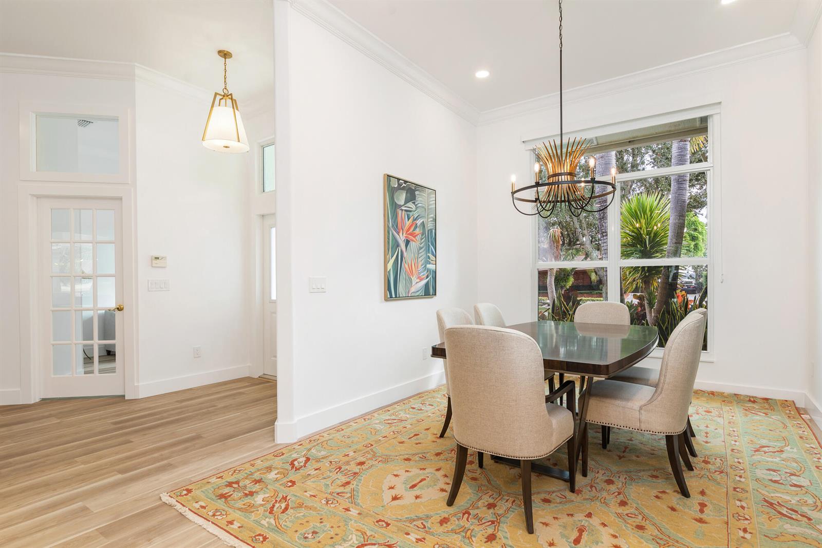 A dining room features a dark wood table, upholstered chairs, a patterned rug, and chandelier — 3317 Embassy Drive, West Palm Beach FL 33401, WEST PALM BEACH, FL