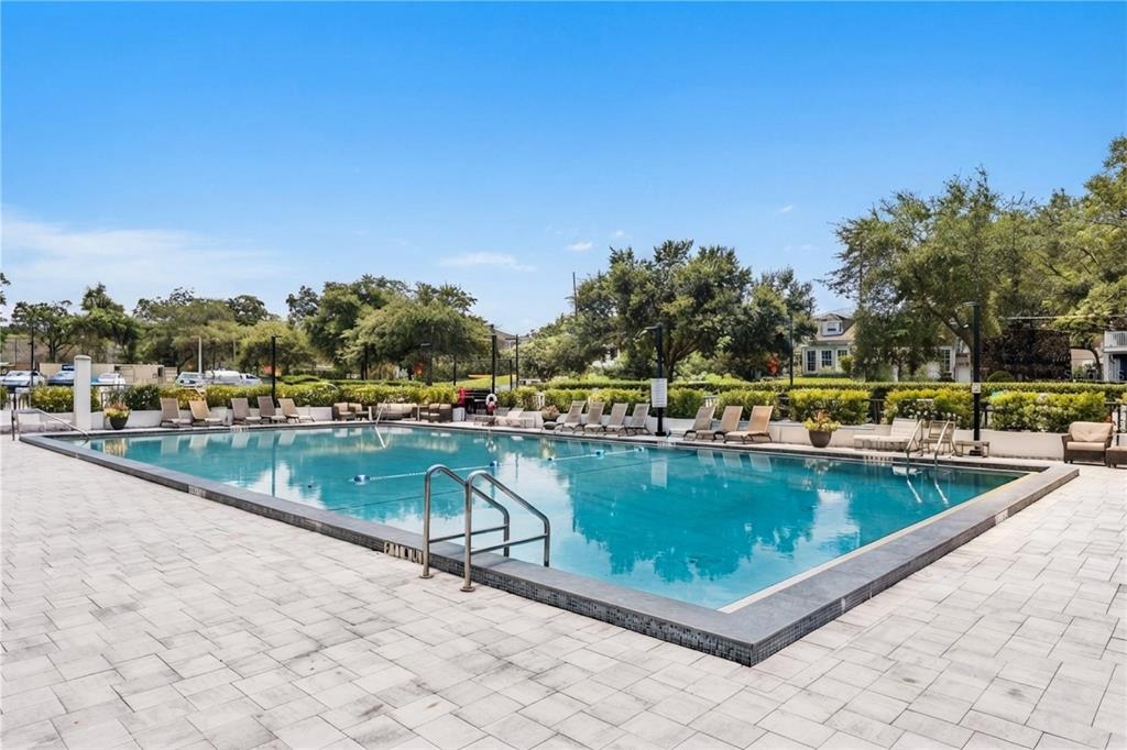 A rectangular swimming pool is surrounded by a paved deck with lounge chairs and landscaping — 400 E COLONIAL DRIVE UNIT 608, ORLANDO, FL