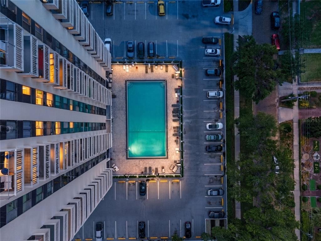 An aerial view shows a tall apartment building next to a rectangular swimming pool and parking — 400 E COLONIAL DRIVE UNIT 608, ORLANDO, FL