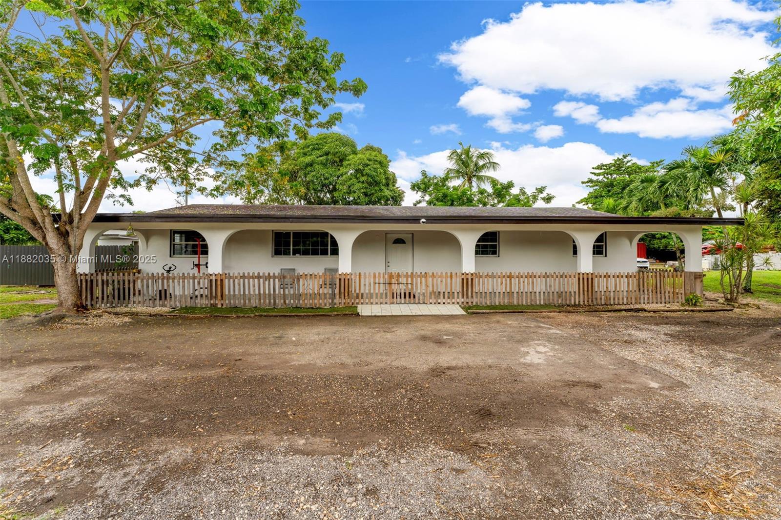 A single-story house with a white arched porch and a wooden picket fence — 12750 SW 197th Ave, Miami FL 33196, MIAMI, FL
