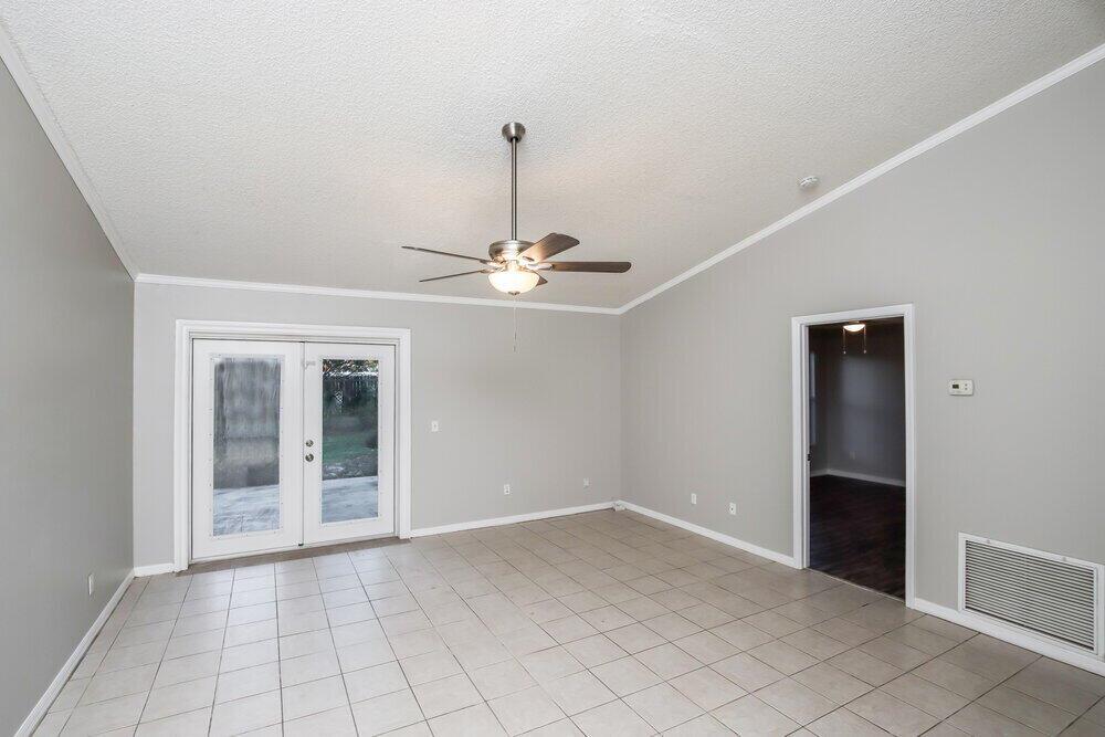 A room with light gray walls, white tile flooring, a ceiling fan, and French doors — SEBASTIAN, FL