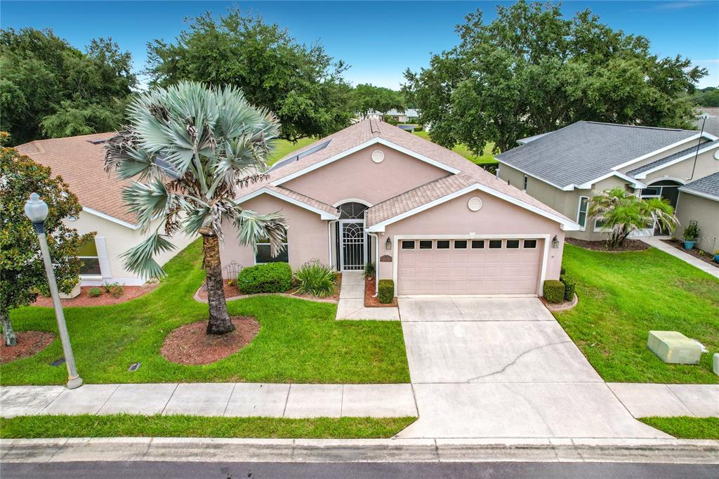 A single-story pink house with a two-car garage and a palm tree in the yard — 4178 CANNES AVENUE, LAKE WALES, FL
