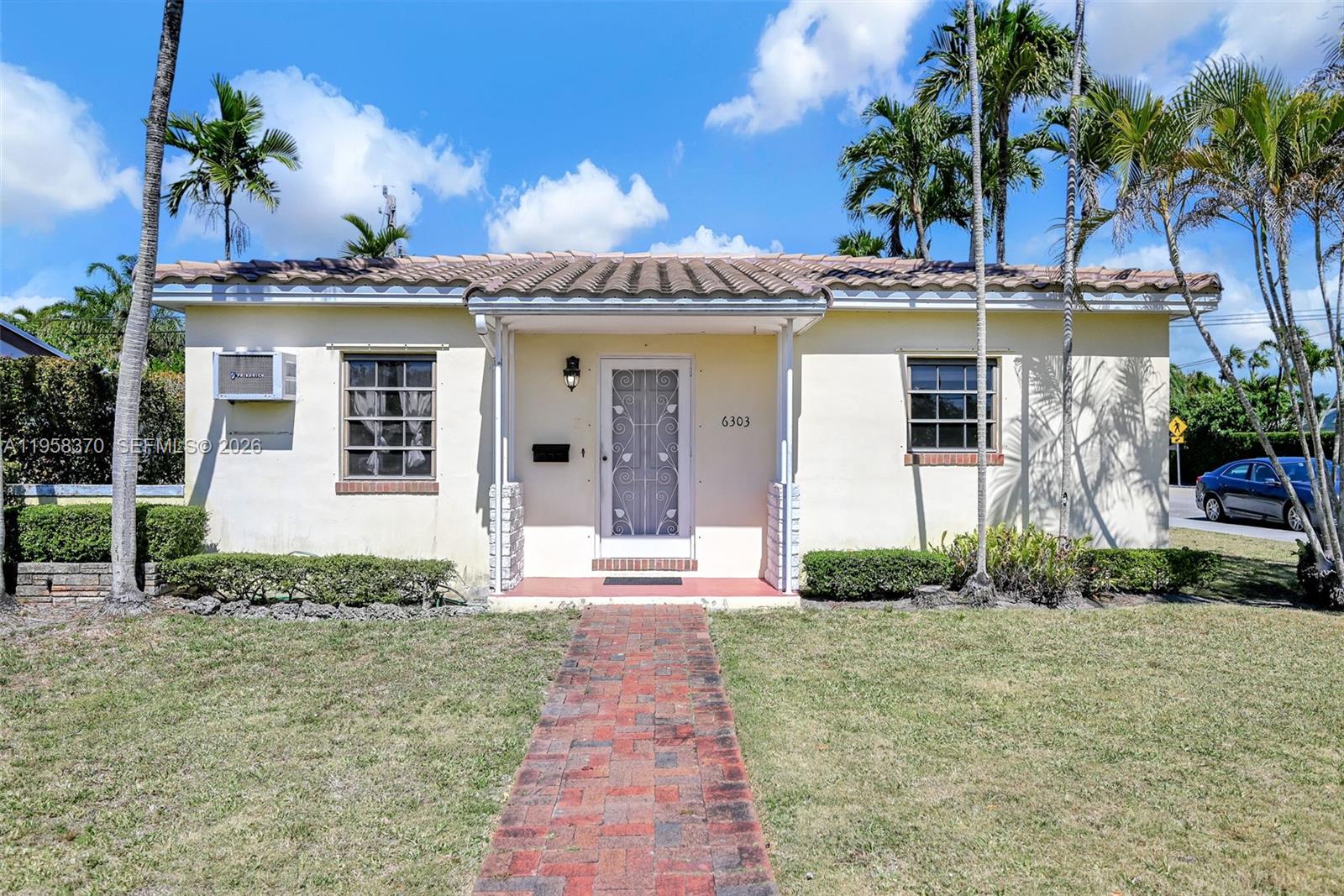 A single-story house with a tiled roof, brick walkway, and palm trees in the yard — 6303 SW 43rd St, South Miami FL 33155, SOUTH MIAMI, FL