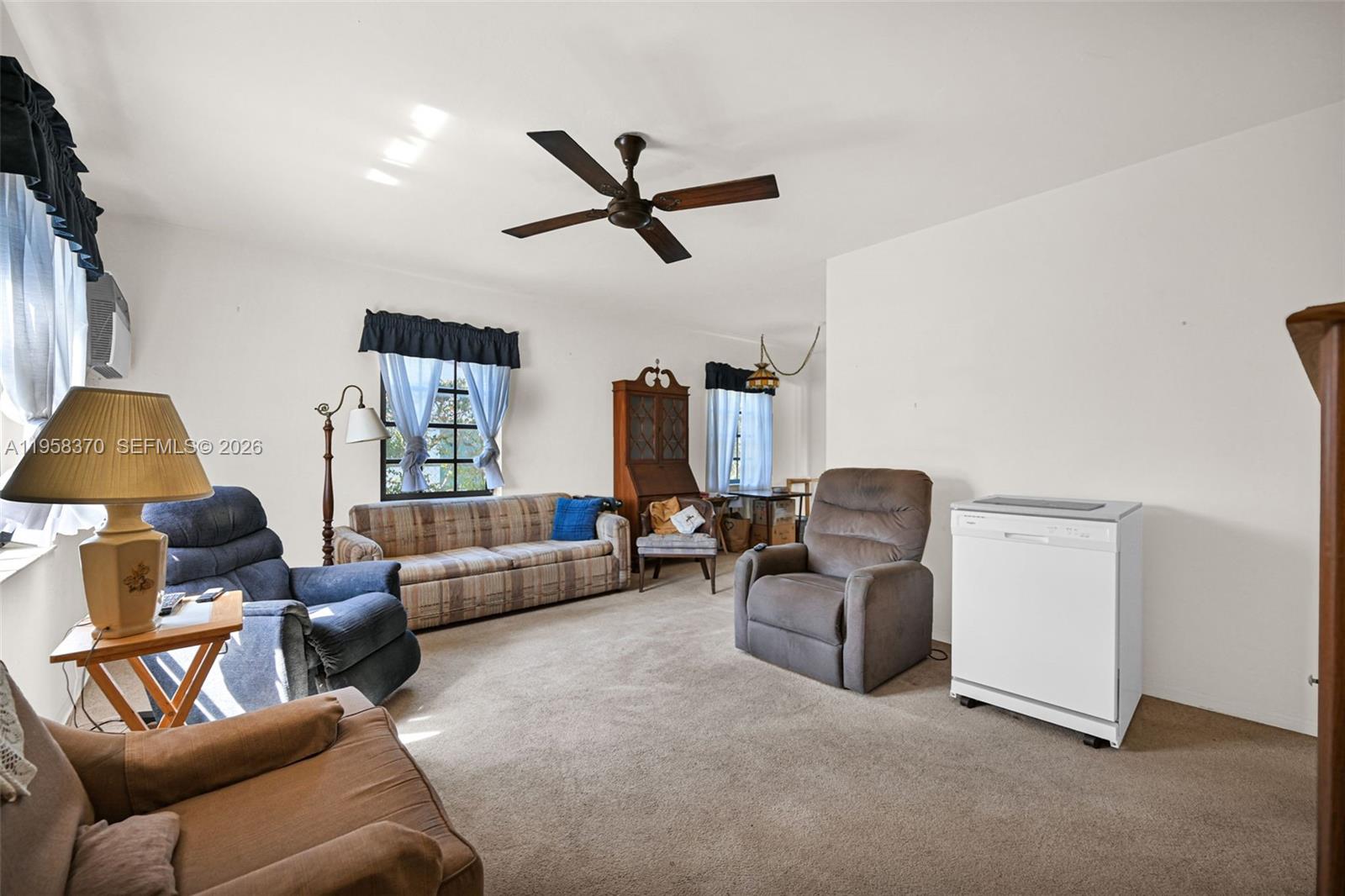 A living room features carpeted floors, a ceiling fan, and various pieces of furniture — 6303 SW 43rd St, South Miami FL 33155, SOUTH MIAMI, FL