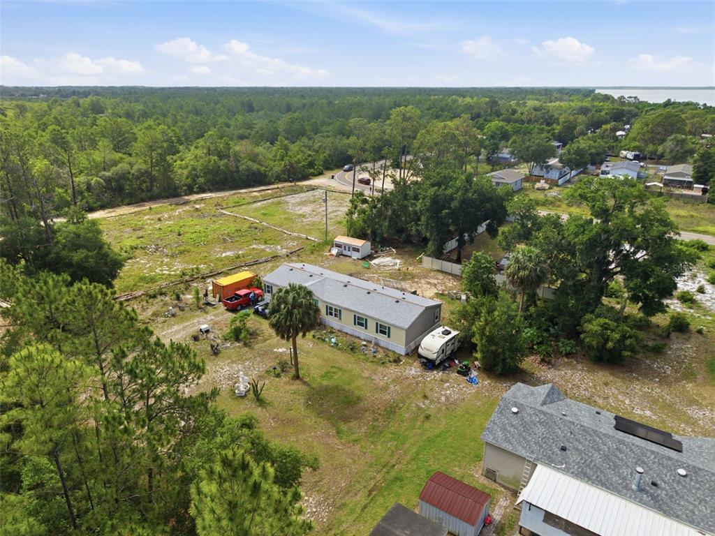 An aerial view shows a manufactured home on a large, partially wooded lot with outbuildings — 9780 MIDWAY ROAD, HAINES CITY, FL