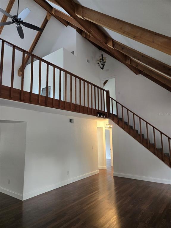 A room with a white brick wall, wood ceiling beams, and a wooden loft railing — 1743 ITCHEPACKESASSA DRIVE, LAKELAND, FL