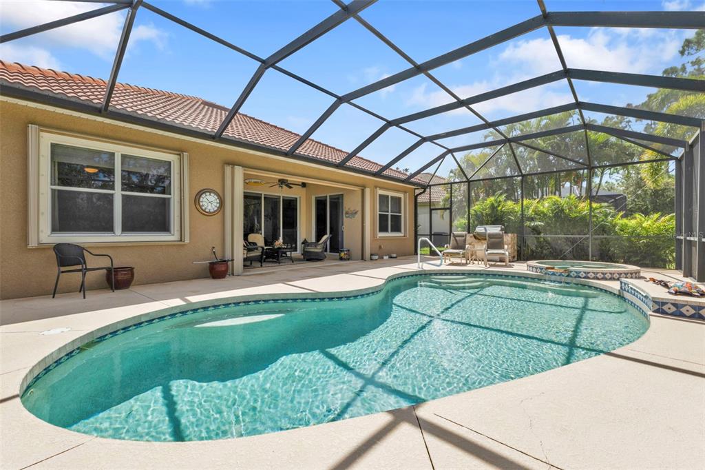 A swimming pool and hot tub are enclosed by a screen cage on a patio — 13139 PRESERVE COURT, PORT CHARLOTTE, FL