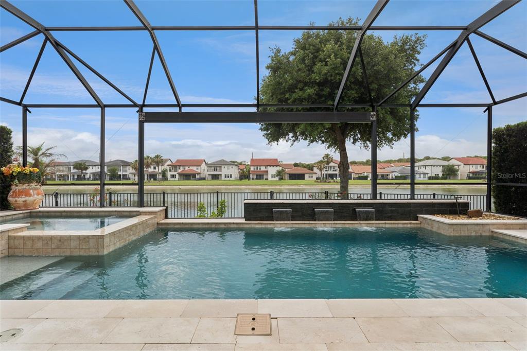 A screened-in pool and spa overlook a lake and residential neighborhood — 10763 ROYAL CYPRESS WAY, ORLANDO, FL