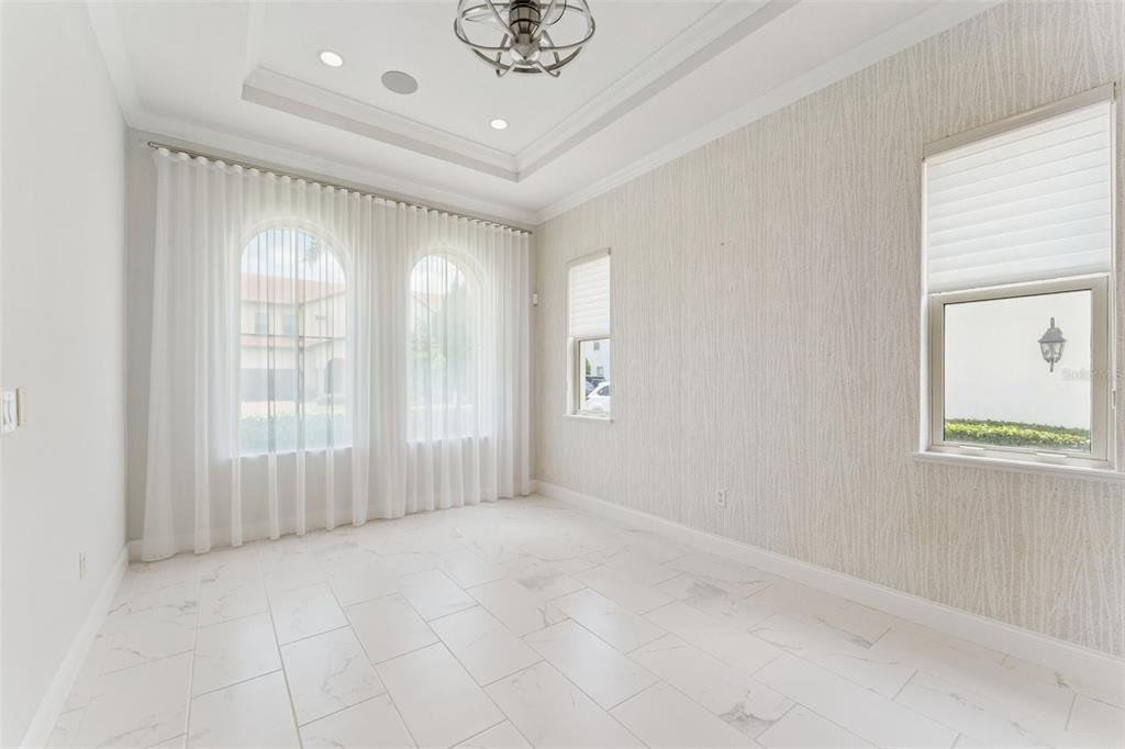 A bright room features white marble-look tile floors, arched windows with sheer curtains, and wallpaper — 10763 ROYAL CYPRESS WAY, ORLANDO, FL