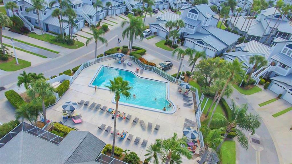 An aerial view of a community swimming pool surrounded by lounge chairs and residential buildings — 1318 SIESTA BAYSIDE DRIVE UNIT C, SARASOTA, FL