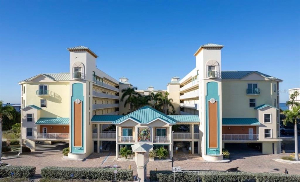 An aerial view of a beach with multi-story residential buildings and a swimming pool — 12000 GULF BOULEVARD UNIT 304-W, TREASURE ISLAND, FL