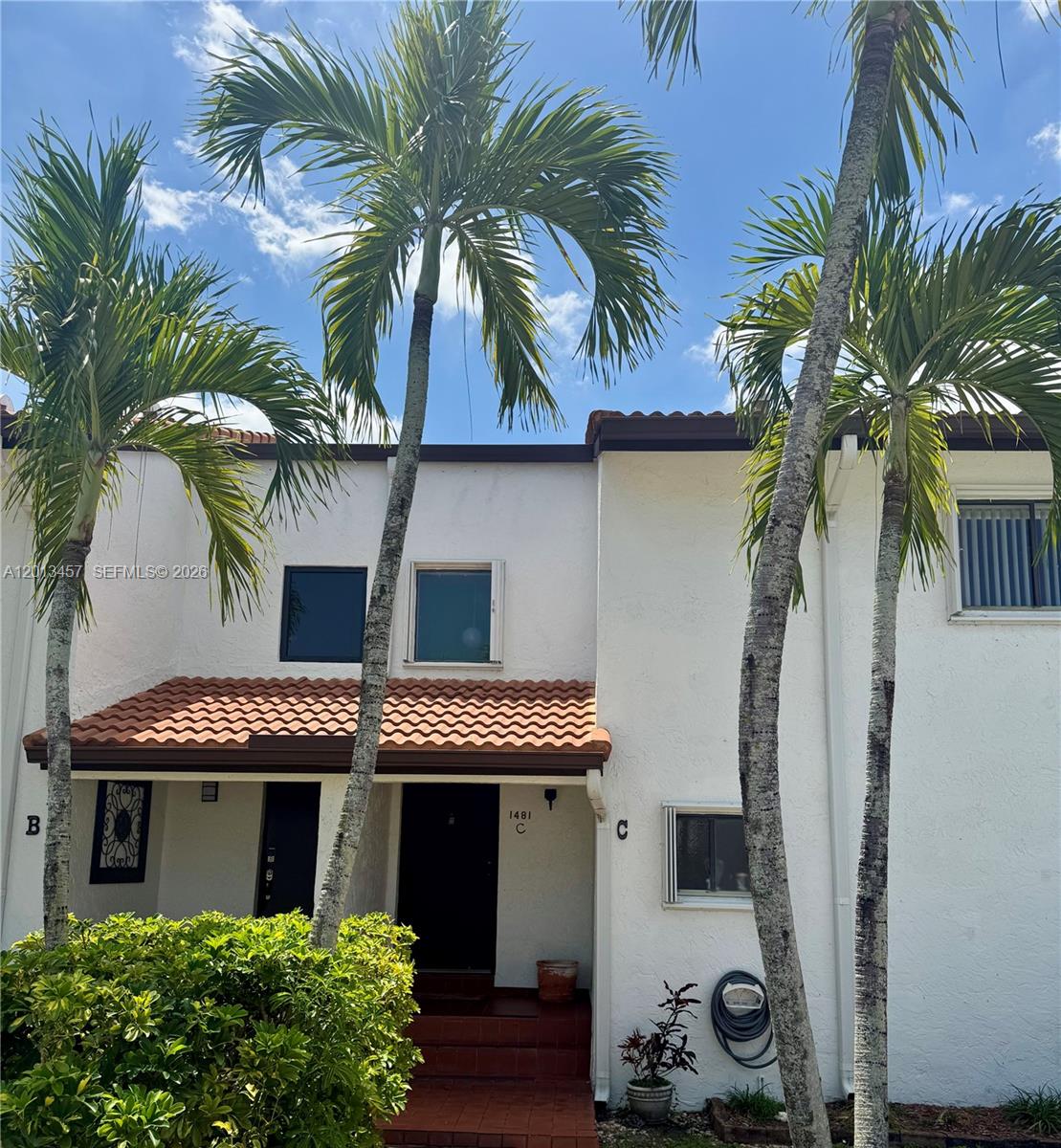 The exterior of a two-story white townhouse features a tiled roof and palm trees — 1481 SW 124th Ct # C, Miami FL 33184, MIAMI, FL