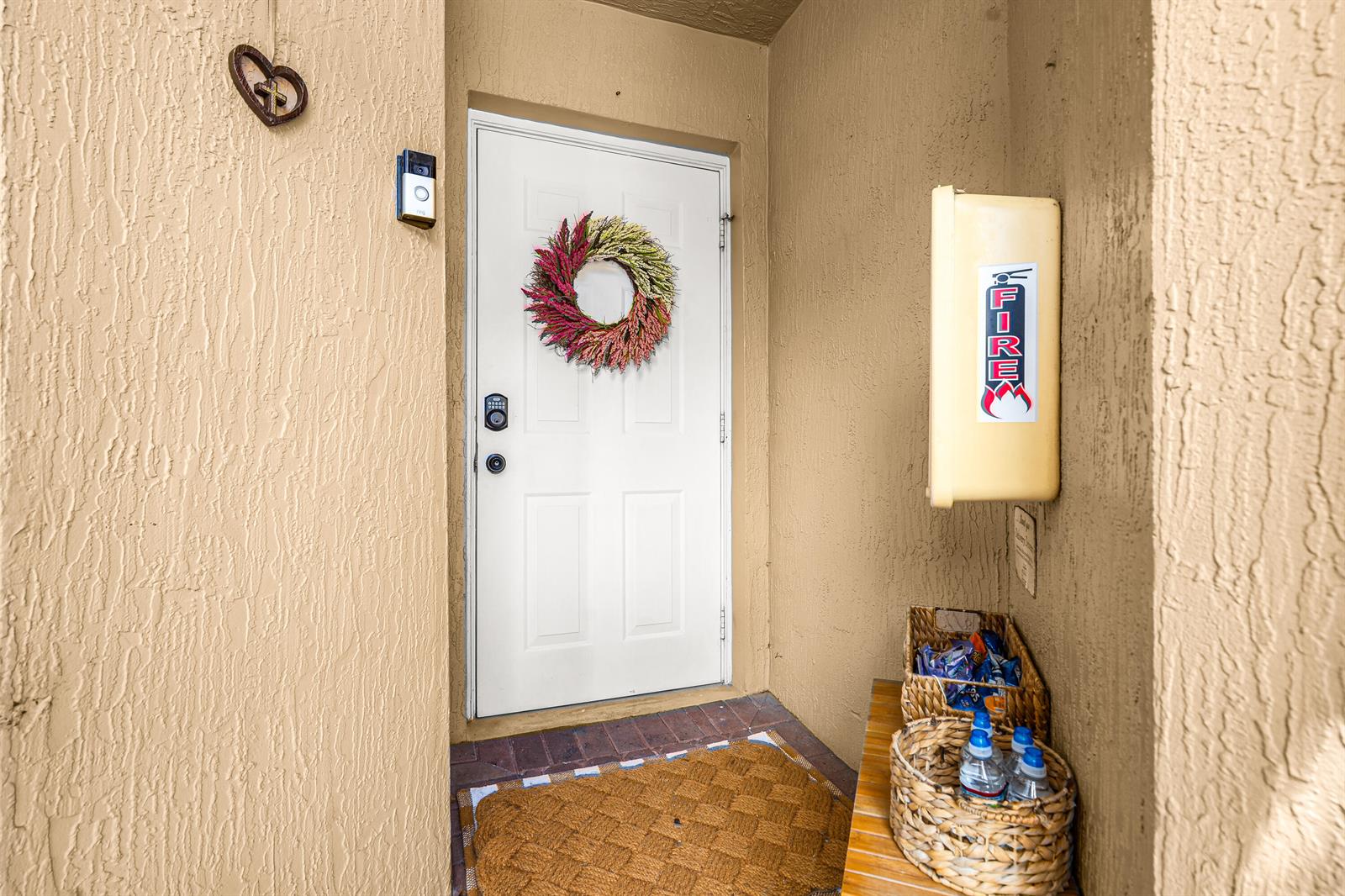 A white front door with a wreath is set in a tan stucco entryway — 7375 NW 61st Terrace # 19, Parkland FL 33067, PARKLAND, FL