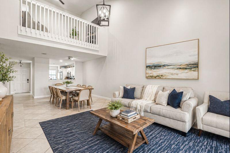 A living room with a loft balcony, dining area, and neutral furniture on a rug — 7375 NW 61st Terrace # 19, Parkland FL 33067, PARKLAND, FL