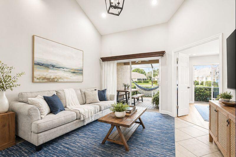 A living room with a gray sofa, blue rug, and sliding doors opening to a patio — 7375 NW 61st Terrace # 19, Parkland FL 33067, PARKLAND, FL