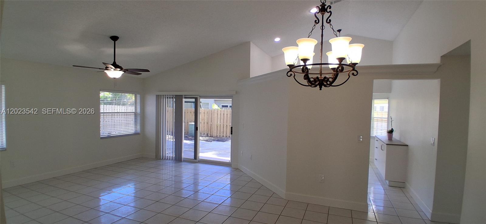 A bright living area features white tile floors, a vaulted ceiling, and a sliding glass door — 3277 NW 123rd Ave, Sunrise FL 33323, SUNRISE, FL