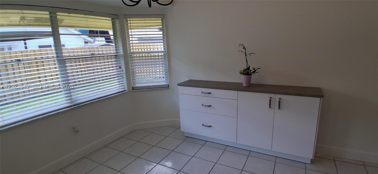 A room with white tile floors, a white cabinet with a gray top, and windows — 3277 NW 123rd Ave, Sunrise FL 33323, SUNRISE, FL