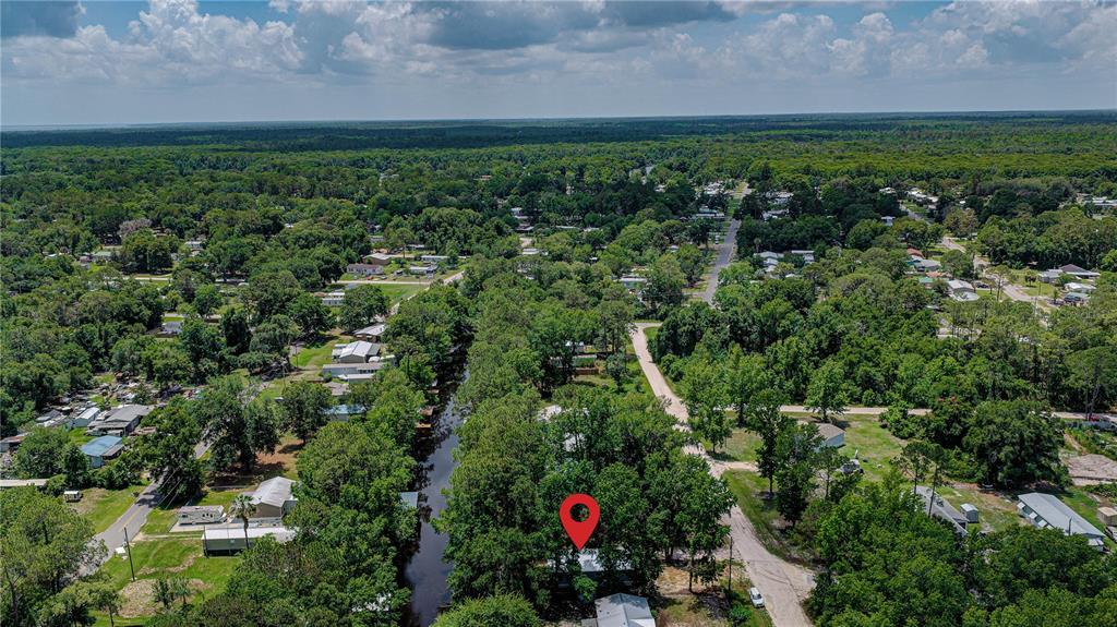 An aerial view shows a house marked by a red pin near a canal — 118 WATERWAY DRIVE, SATSUMA, FL