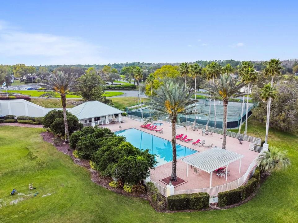 An aerial view shows a swimming pool, a covered patio, and tennis courts — 9104 WADE STREET UNIT Plan 2, WEEKI WACHEE, FL