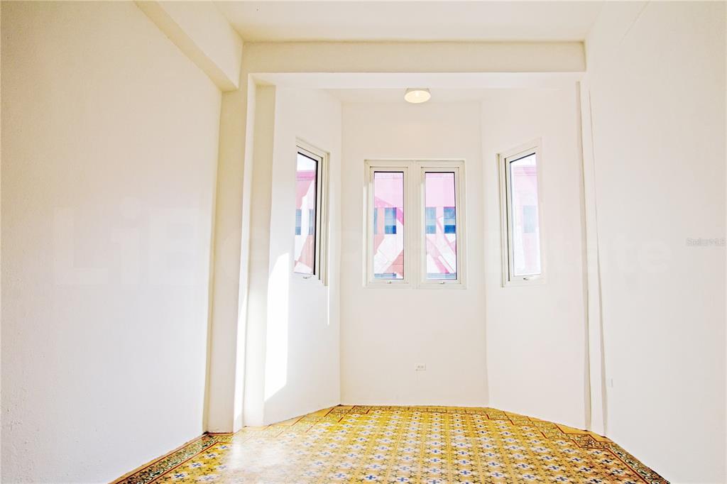 An empty room features white walls, a patterned tile floor, and a bay window — 319 RECINTO SUR STREET UNIT 2, SAN JUAN, PR