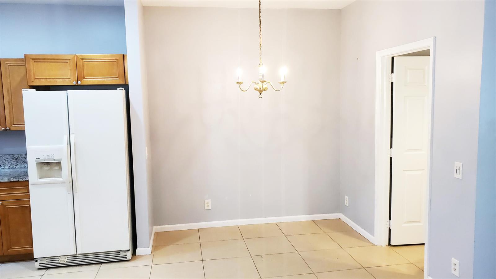 A dining area features light gray walls, tile flooring, and a brass chandelier — 132 Baldwin Boulevard, FL 33463, FL