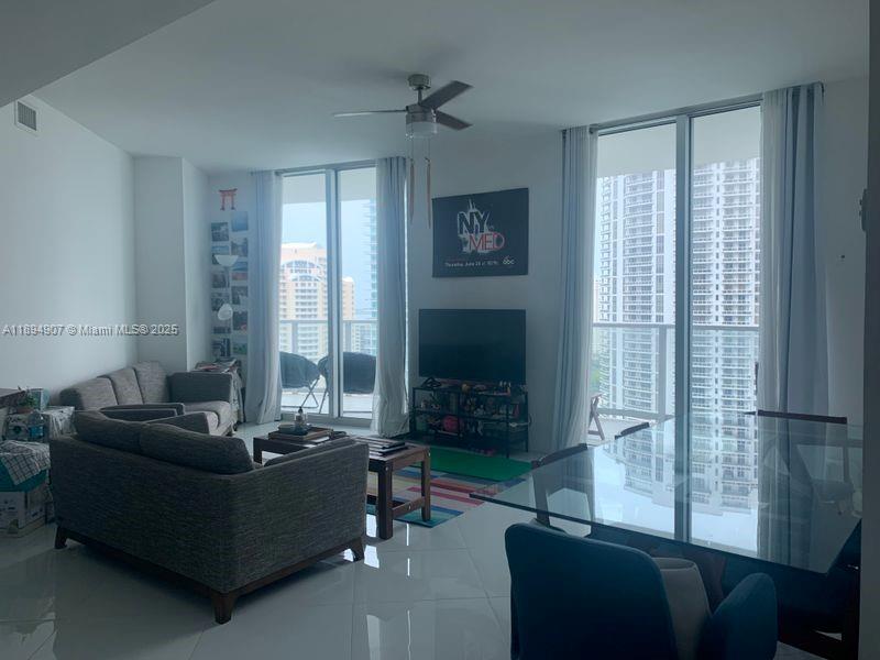 A living and dining area with tile floors, a ceiling fan, and floor-to-ceiling windows — 300 S Biscayne Blvd # 1908, Miami FL 33131, MIAMI, FL