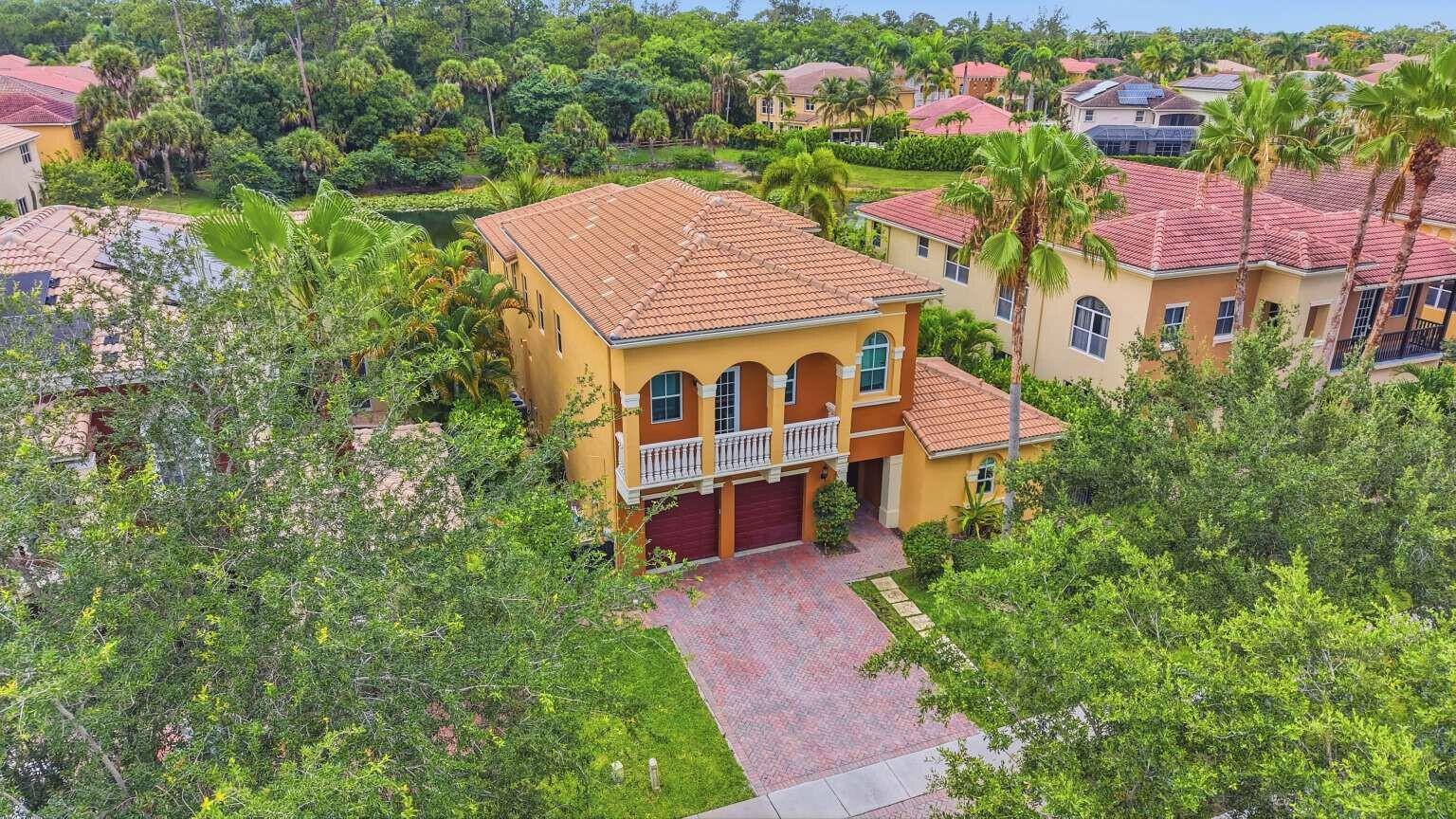 An aerial view of a two-story yellow stucco house with a red tile roof — 9190 Nugent Trail, West Palm Beach FL 33411, WEST PALM BEACH, FL