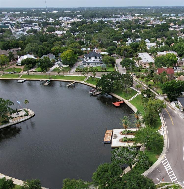An aerial view shows a waterfront property with a large house, docks, and surrounding trees — LEMON STREET, TARPON SPRINGS, FL