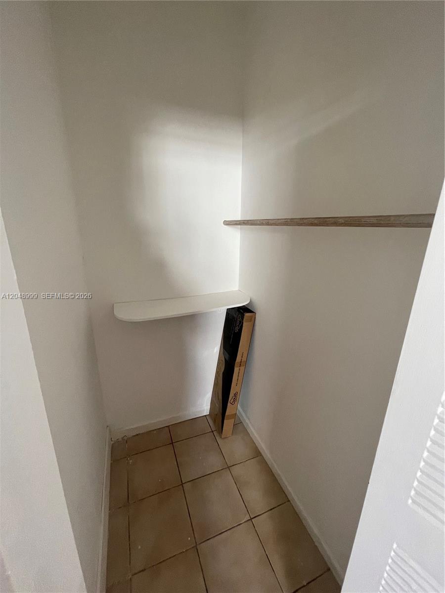 This small closet features white walls, a single shelf, and tiled flooring — 453 SW 19th Rd Rear, Miami FL 33129, MIAMI, FL