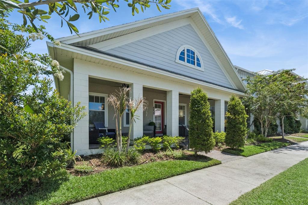 A light blue house with a white-columned front porch and a red front door — 6839 BRIDGMAN STREET, ORLANDO, FL