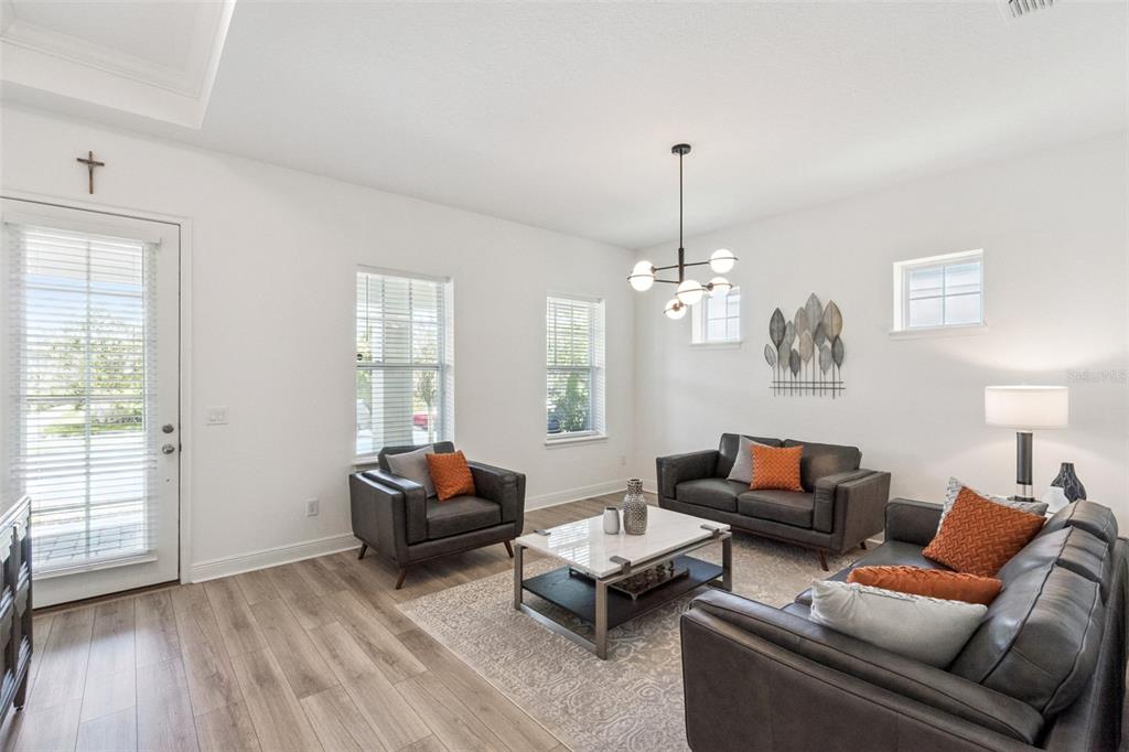 A living room features gray leather furniture, a marble coffee table, and a modern chandelier — 6839 BRIDGMAN STREET, ORLANDO, FL