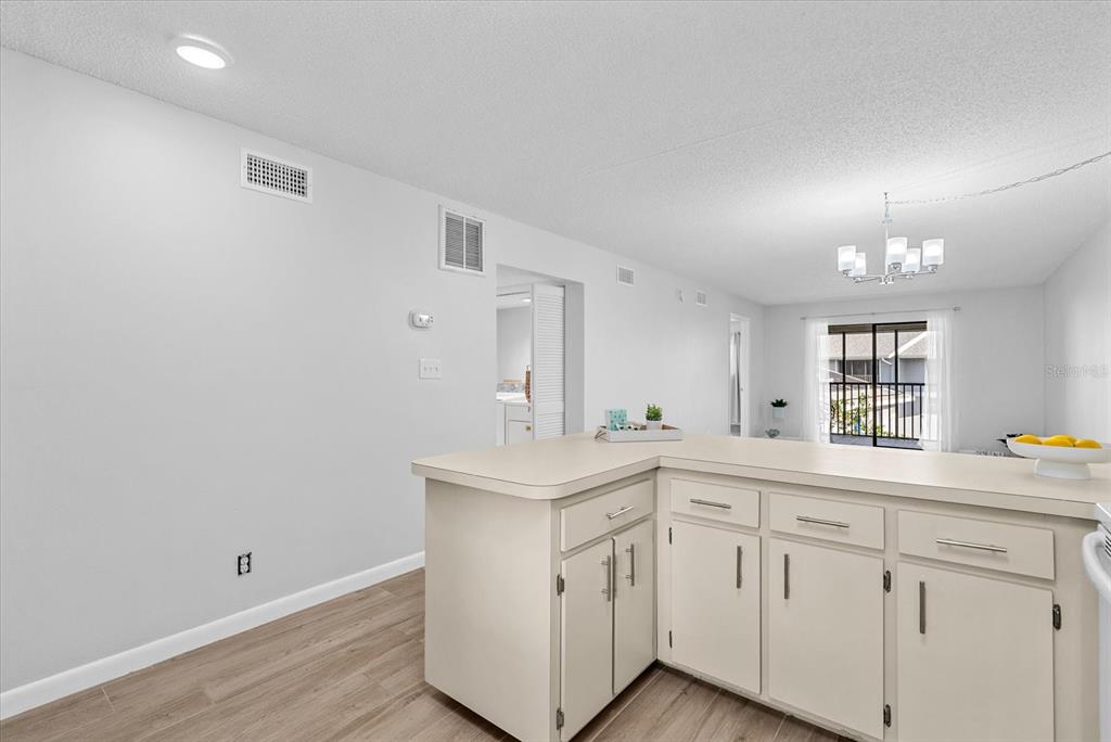 A kitchen island with light-colored cabinets sits in a room with wood-look flooring — 6033 34TH STREET W UNIT 28, BRADENTON, FL